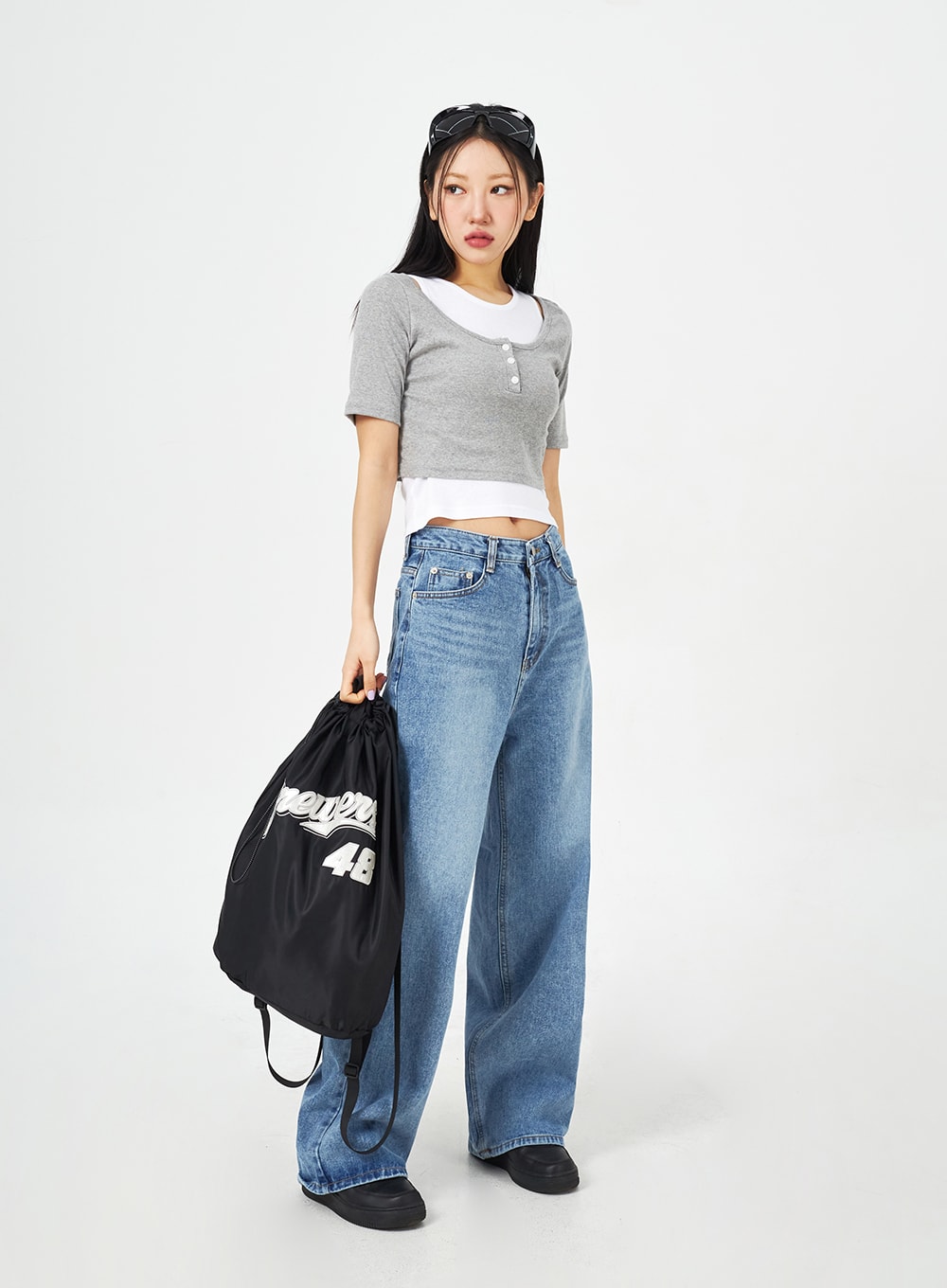 Mid-Wash Bootcut Jeans CM323 in mid blue, full-length turned pose on model with drawstring bag, wide-fit washed denim showing leg width and bootcut silhouette from side angle.