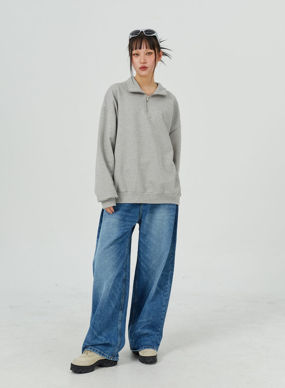 Oversized Jeans Unisex CM321 in blue, full-length slight side-front on model, wide-leg denim with washed finish, paired with grey half-zip sweatshirt.