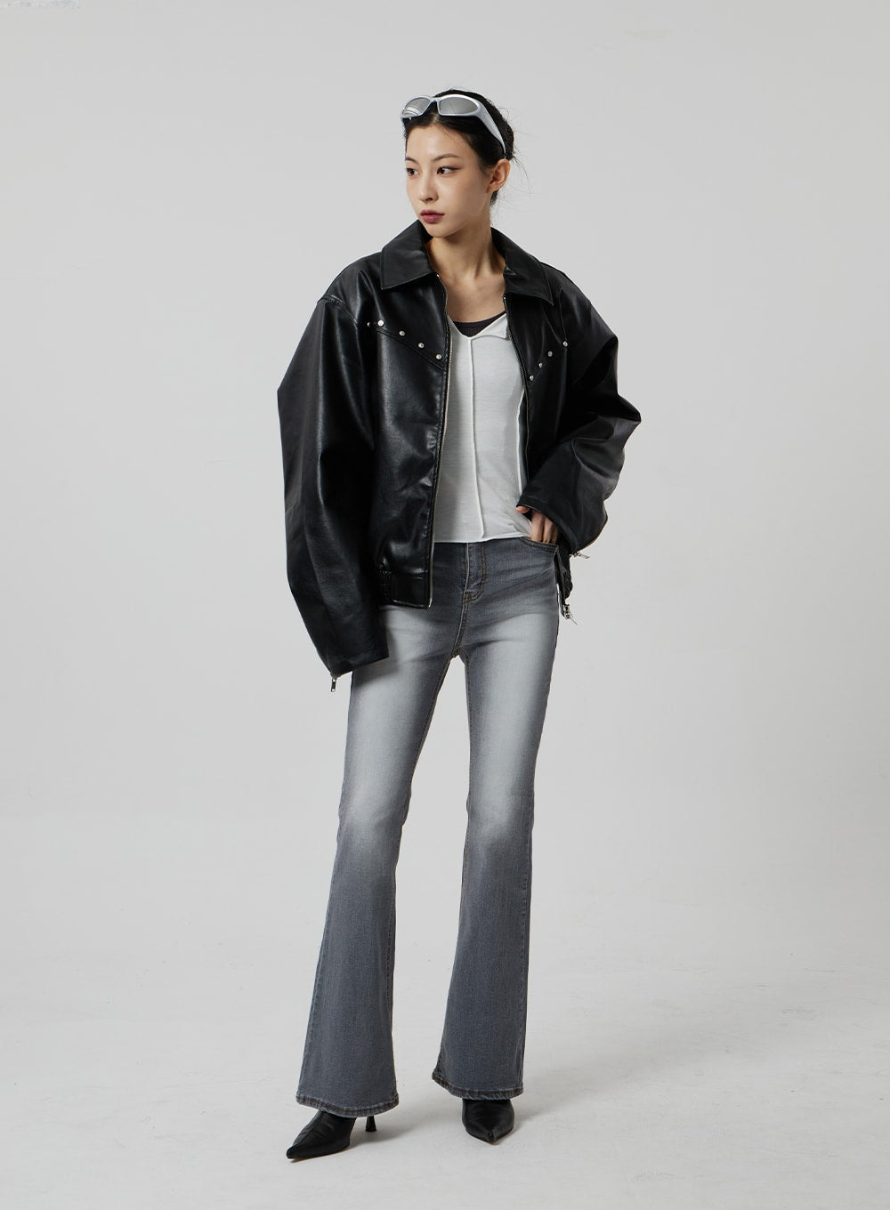 Slim Fit Bootcut Jeans CF307 in grey, full-length front view on model looking aside, slim-fit bootcut with faded wash, layered under open black faux-leather jacket and white tee.