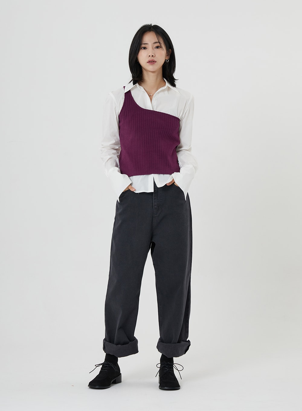 Maxi Denim Pants ON23 in charcoal grey, full-body front shot on model hands in pockets, relaxed wide-leg denim with rolled cuffs, worn with white shirt and purple knit vest, black oxfords.
