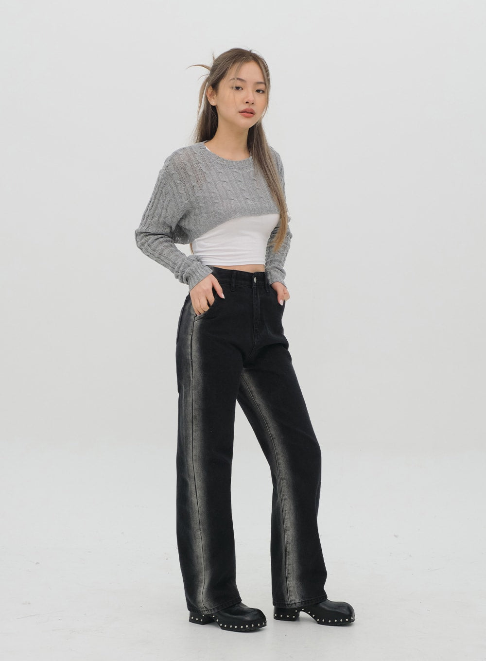 Black Jeans C1002 in washed black, three-quarter side front shot on model, bold contrast fade stripe down leg visible, wide-fit high-rise cotton denim, styled with grey cable-knit crop.