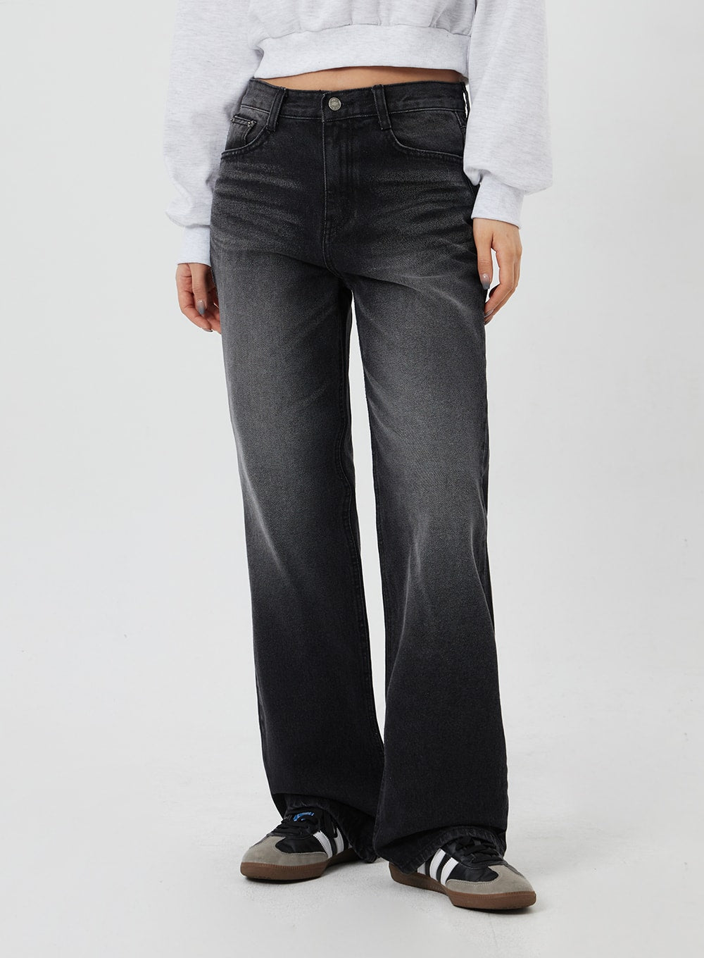 Mid-Rise Bootcut Jeans CF327 in black, front lower-body close-up on model, washed denim fade gradient from hip to hem, wide bootcut leg grazing sneakers.
