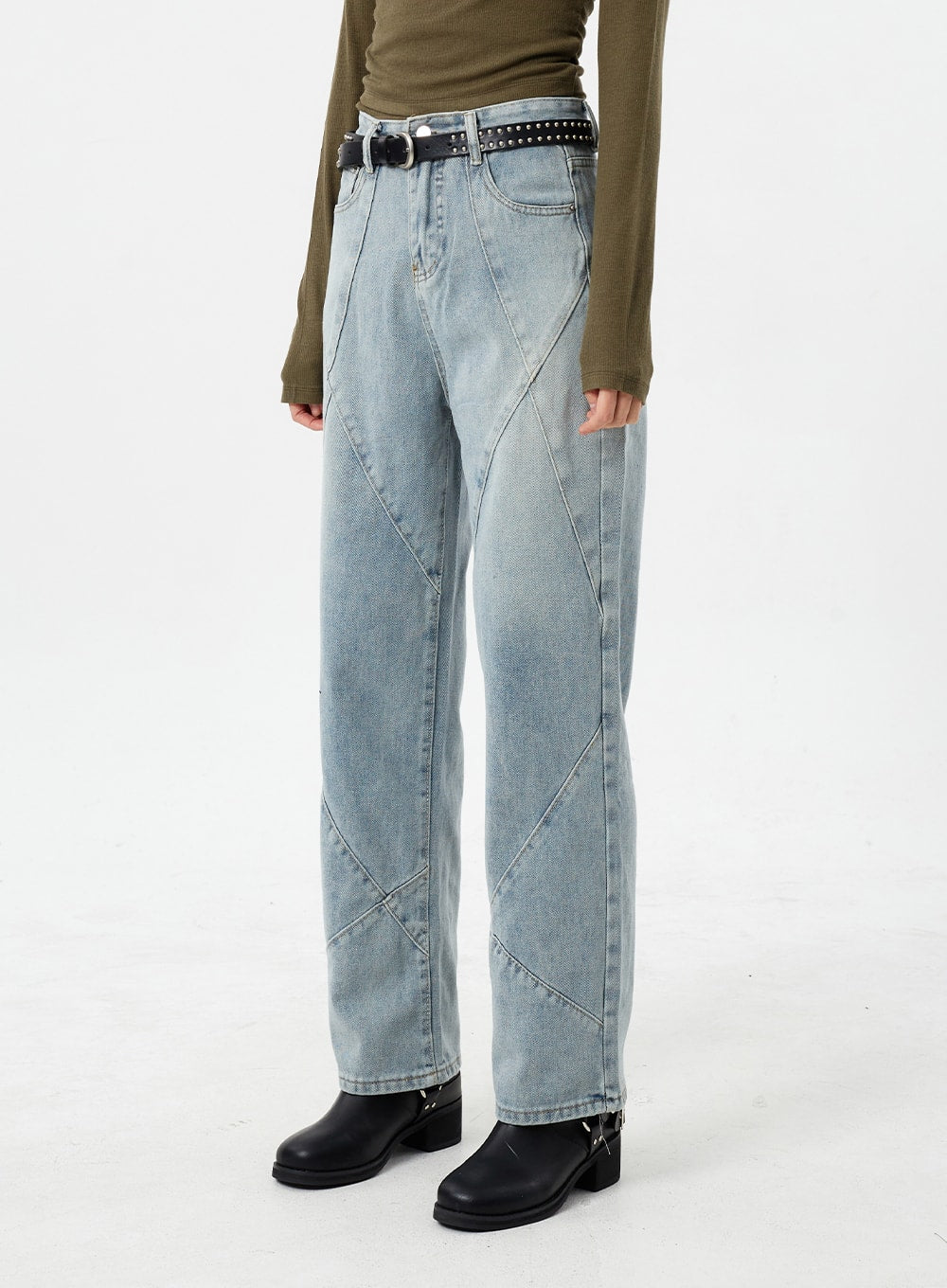 Light Wash Straight Leg Jeans CM307 in light blue, side mid-shot on model, angled close-up highlighting diagonal patchwork seams on straight-fit denim, with studded belt and olive top.