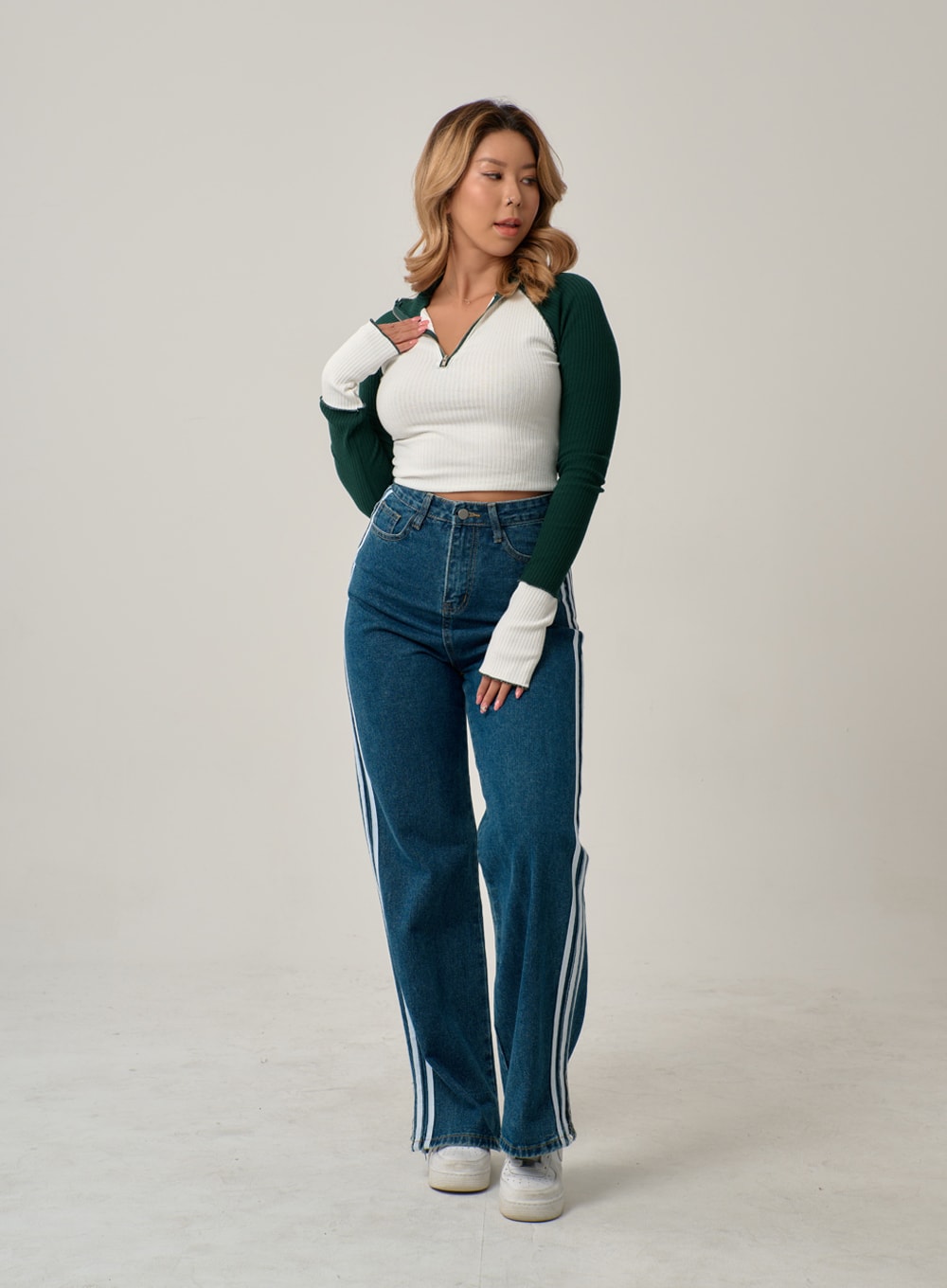 Side Stripes Straight Leg Jeans IN22 in mid blue, three-quarter front shot on model with slight turn, high-rise wide-leg denim with three white side stripes, paired with colorblock ribbed zip crop top.
