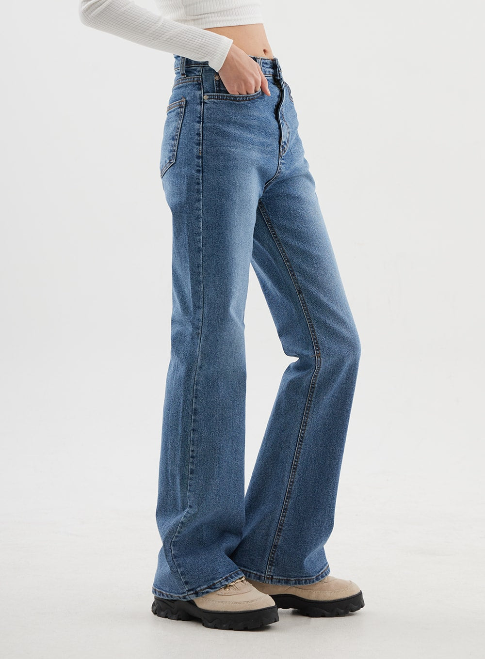 Slim Fit Bootcut Jeans CJ311 in medium blue, side view on model, clean side seam, slim silhouette transitioning to bootcut flare at hem, hand in front pocket, washed denim finish.