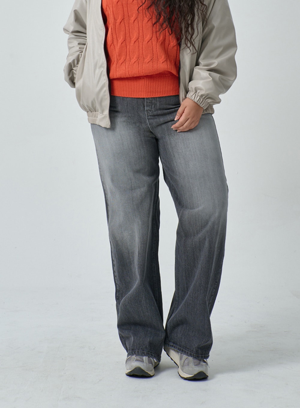 Plus Light Wash Wide Leg Jeans IF317 in grey wash, front waist-to-hem close-up on plus-size model, wide leg washed denim with low-rise waistband, layered under beige bomber jacket and orange sweater.