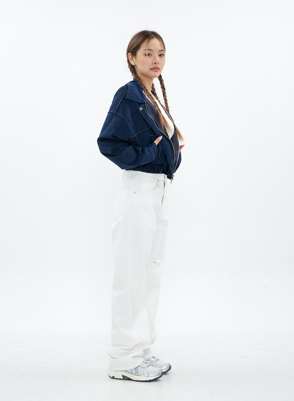 Torn Wide Leg Jeans CM18 in white, full-body side view on model, showcasing wide-leg silhouette and long length, knee cut-out detail visible, paired with navy jacket and sneakers.