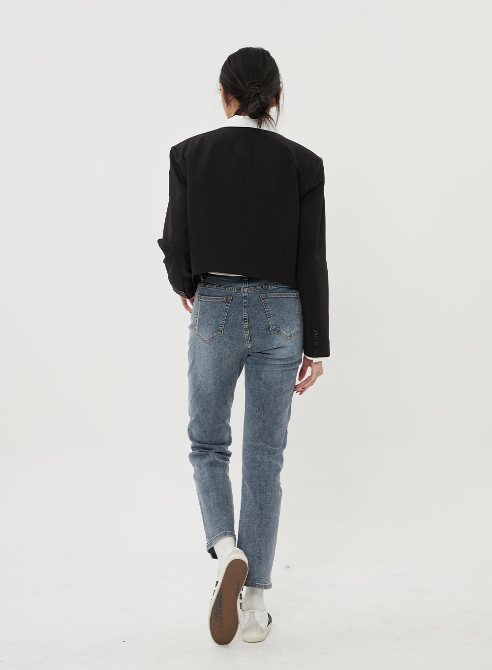 Straight Leg Ankle Jeans BF316 in mid-blue wash, back view on model walking, rear patch pockets with vintage-wash fading, slim straight leg and ankle hem, layered with black blazer.