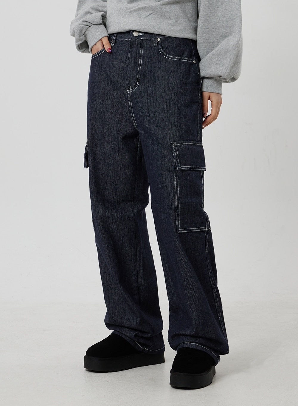 Wide Cargo Jeans CF302 in dark indigo, waist-to-hem side-front close-up on model, double cargo pocket layout with contrast white topstitch detail, wide-leg cotton denim.