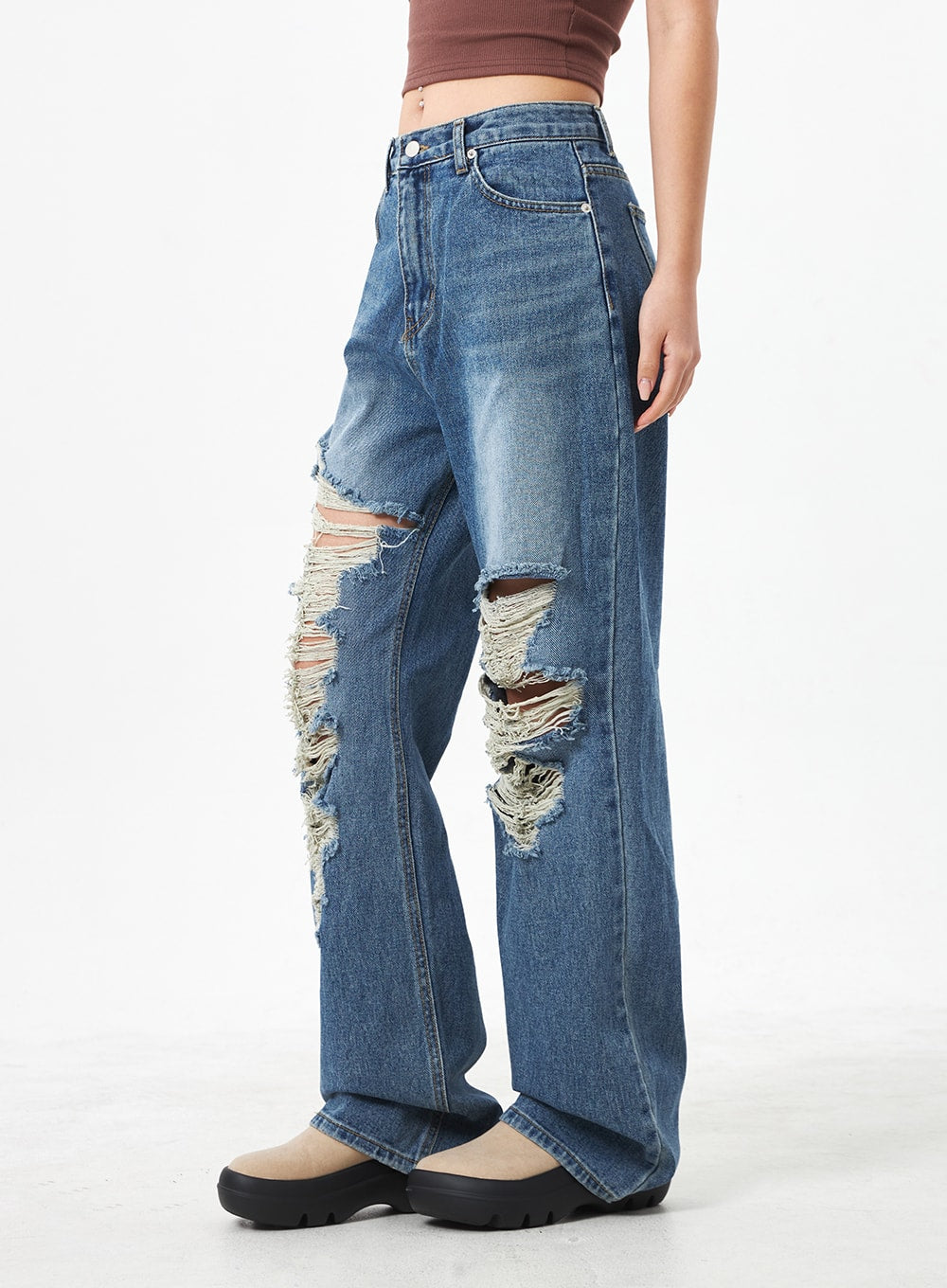 Wide Ripped Jeans CA304 in medium blue, side close-up on model from waist to hem, detailing large destroyed knee tears with raw frayed edges and washed cotton denim texture.