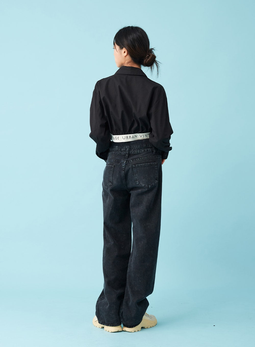 Four Buttoned Open Black Jeans CU8 in washed black, back full-body view on model, rear pockets and wide-leg denim cut visible, logo waistband detail at back, paired with black crop shirt.