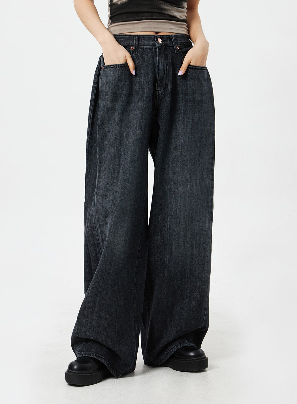 Mid-Rise Baggy Jeans CM324 in washed black denim, front mid-section close-up on model with hands in pockets, mid-rise fit with copper button closure and wide-leg drape.
