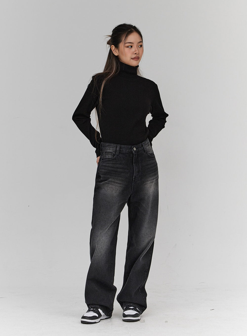 Light Washing Wide Leg Black Jeans CN23 in washed black, full-length side-angle view on model, wide leg washed denim, model looking over shoulder, paired with black ribbed turtleneck.