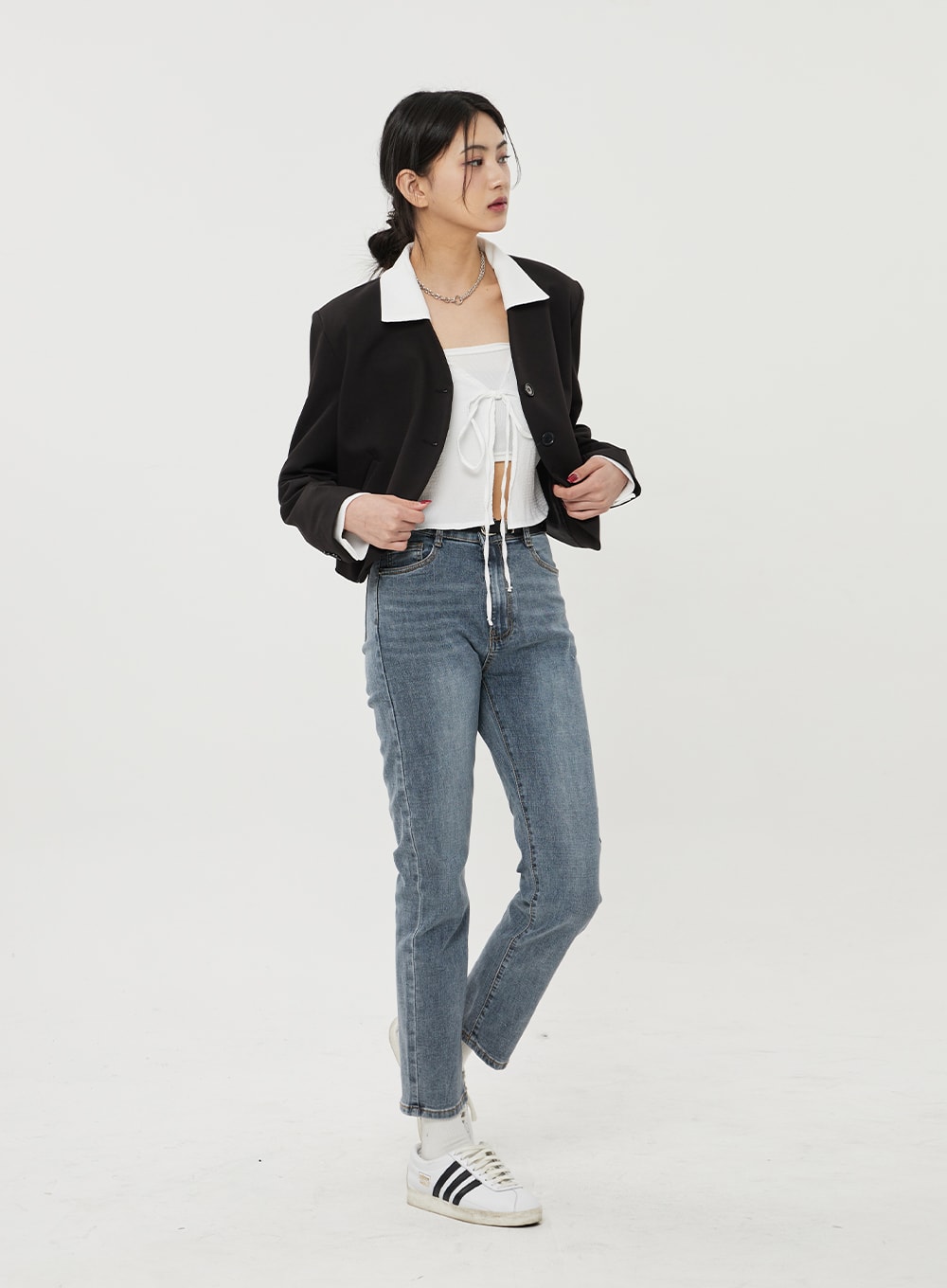 Straight Leg Ankle Jeans BF316 in mid-blue wash, side-angled view on model, slim straight cut and ankle-cropped length, high-rise waist, styled under black cropped blazer and sneakers.