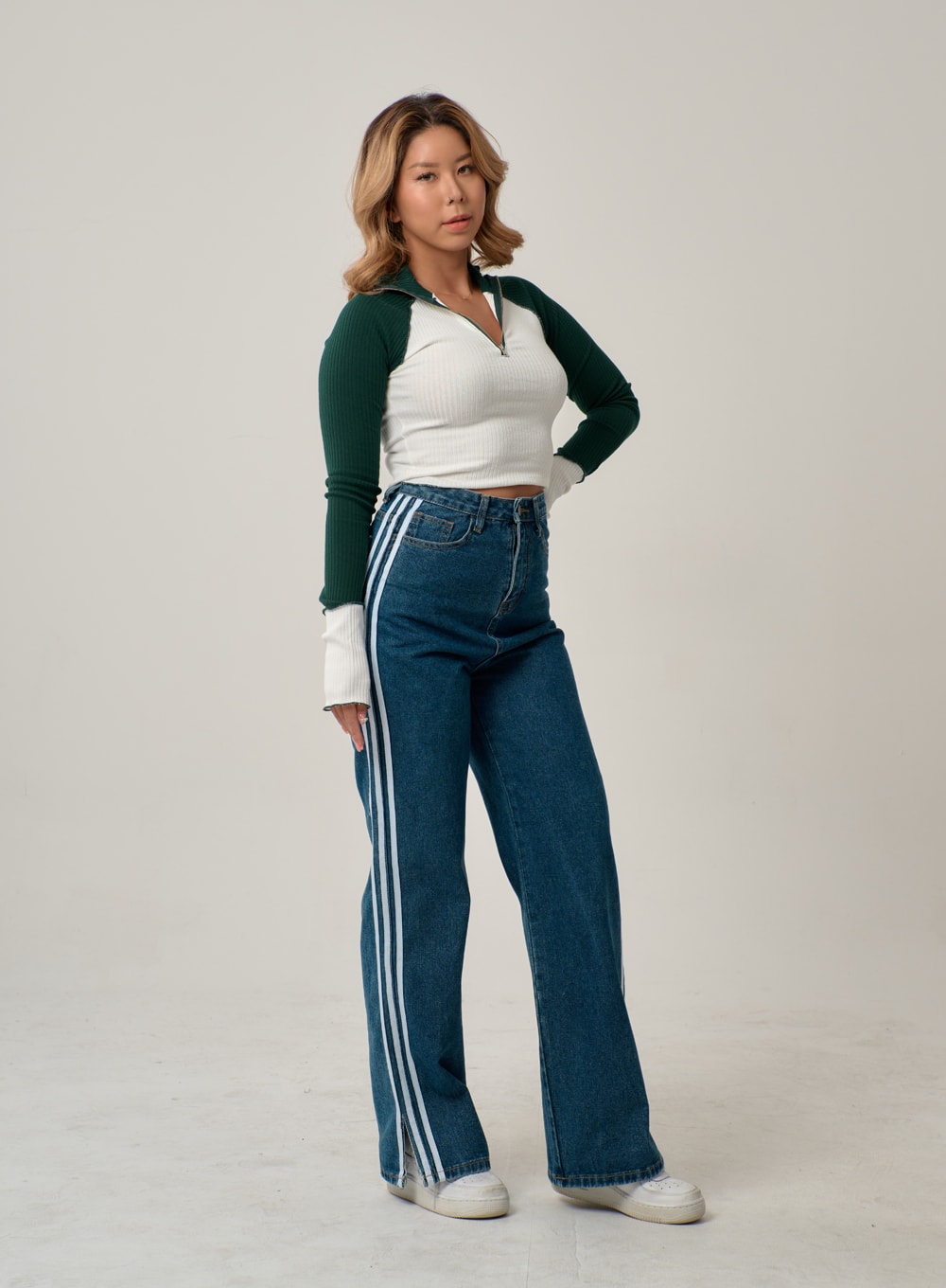 Side Stripes Straight Leg Jeans IN22 in mid blue, three-quarter front-angled shot on model, high-rise wide-fit denim with white side stripes visible along outer leg, styled with ribbed crop top.