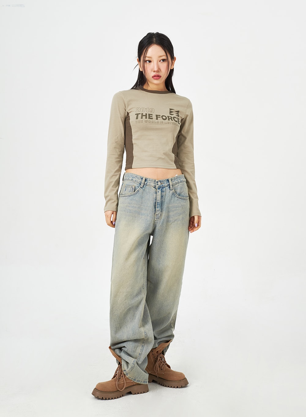 Light Blue Baggy Jeans CM323 in light blue, full-length front shot on model arms relaxed, wide-fit washed denim with faded finish, worn with khaki crop top and brown lace-up boots.