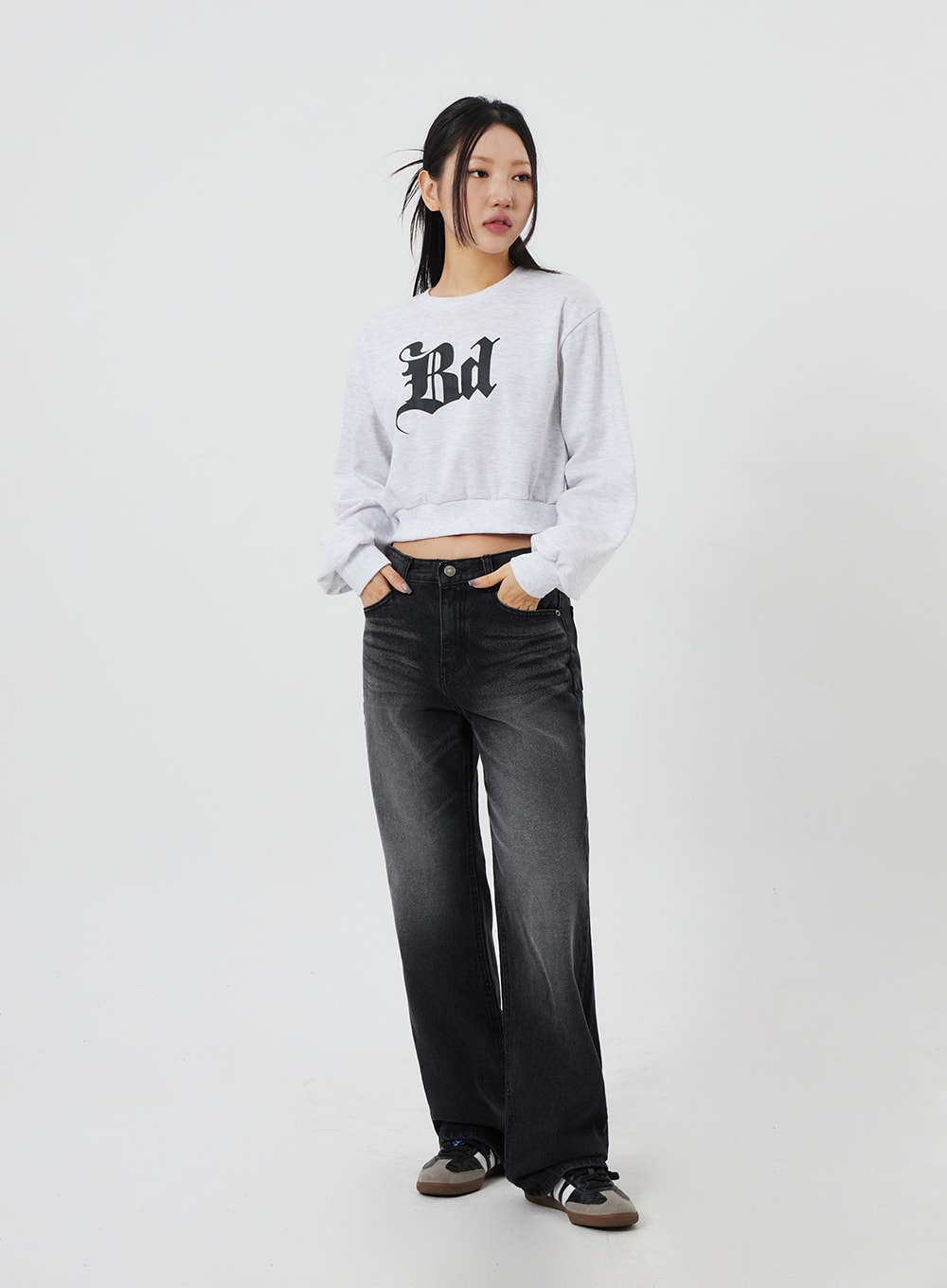 Mid-Rise Bootcut Jeans CF327 in black, full-body front on model with hands in pockets, relaxed pose highlighting regular fit and full-length bootcut leg, grey crop sweatshirt styled on top.