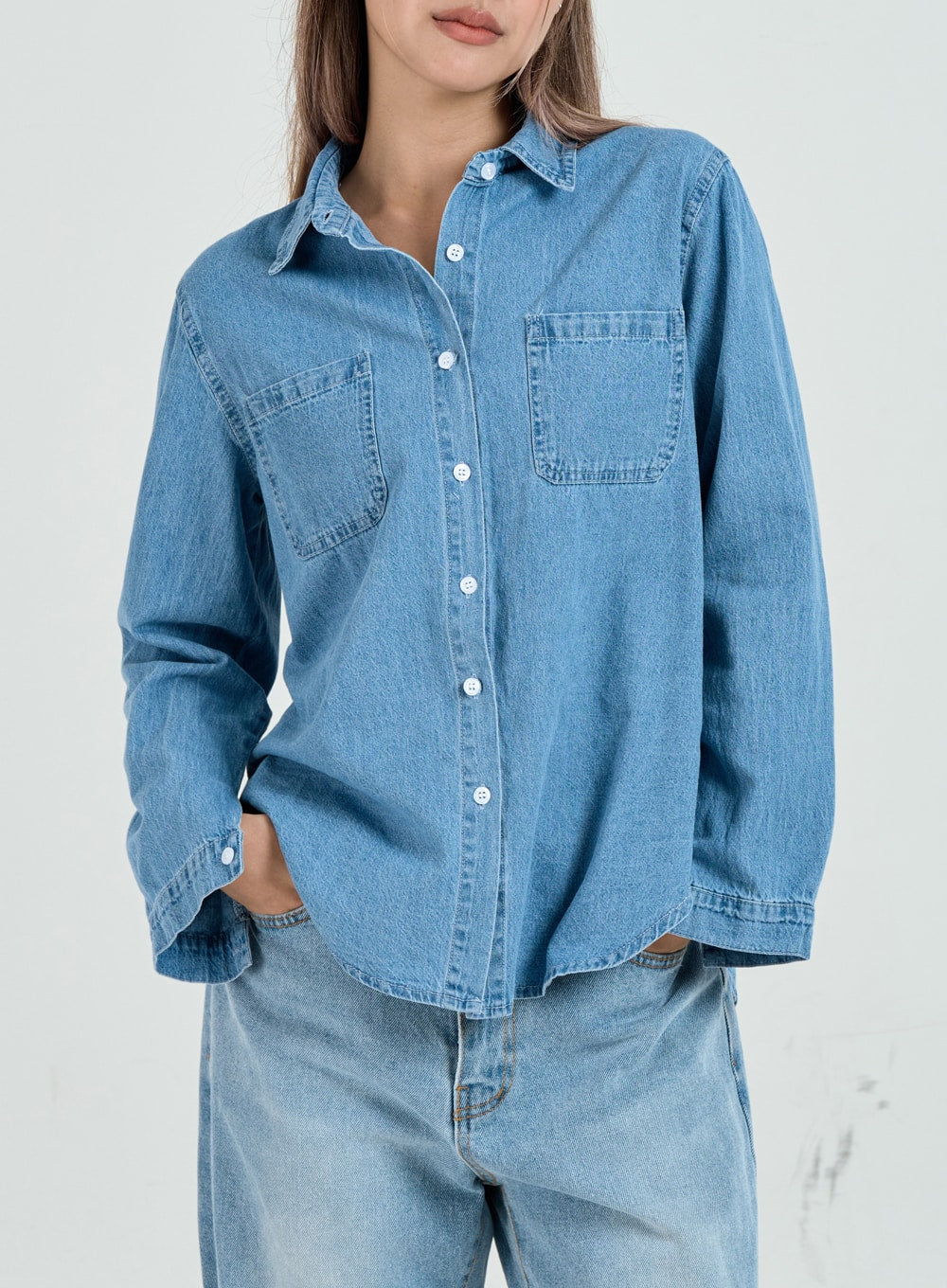 Ripped Maxi Denim Pants Unisex CO14 in light blue, upper-body front close-up on model showing waistband and top of wide-fit denim, paired with blue denim shirt.
