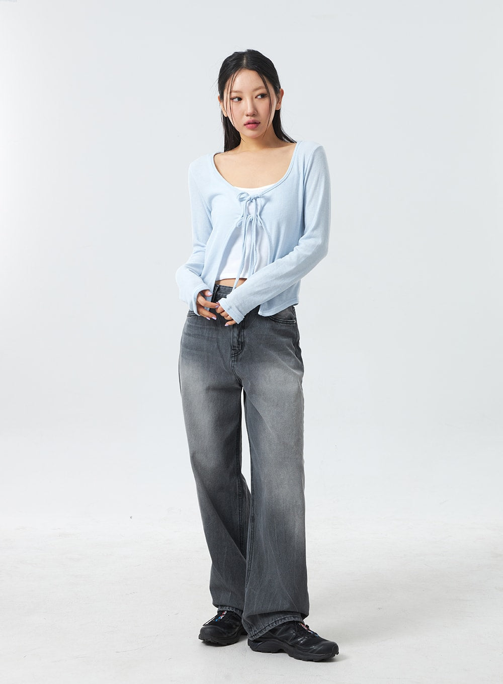 Low Rise Mid-Wash Jeans CM327 in grey, full-length front shot on model with hands near waistband, low-rise wide-fit cotton denim in grey mid-wash, styled with sky blue crop top.