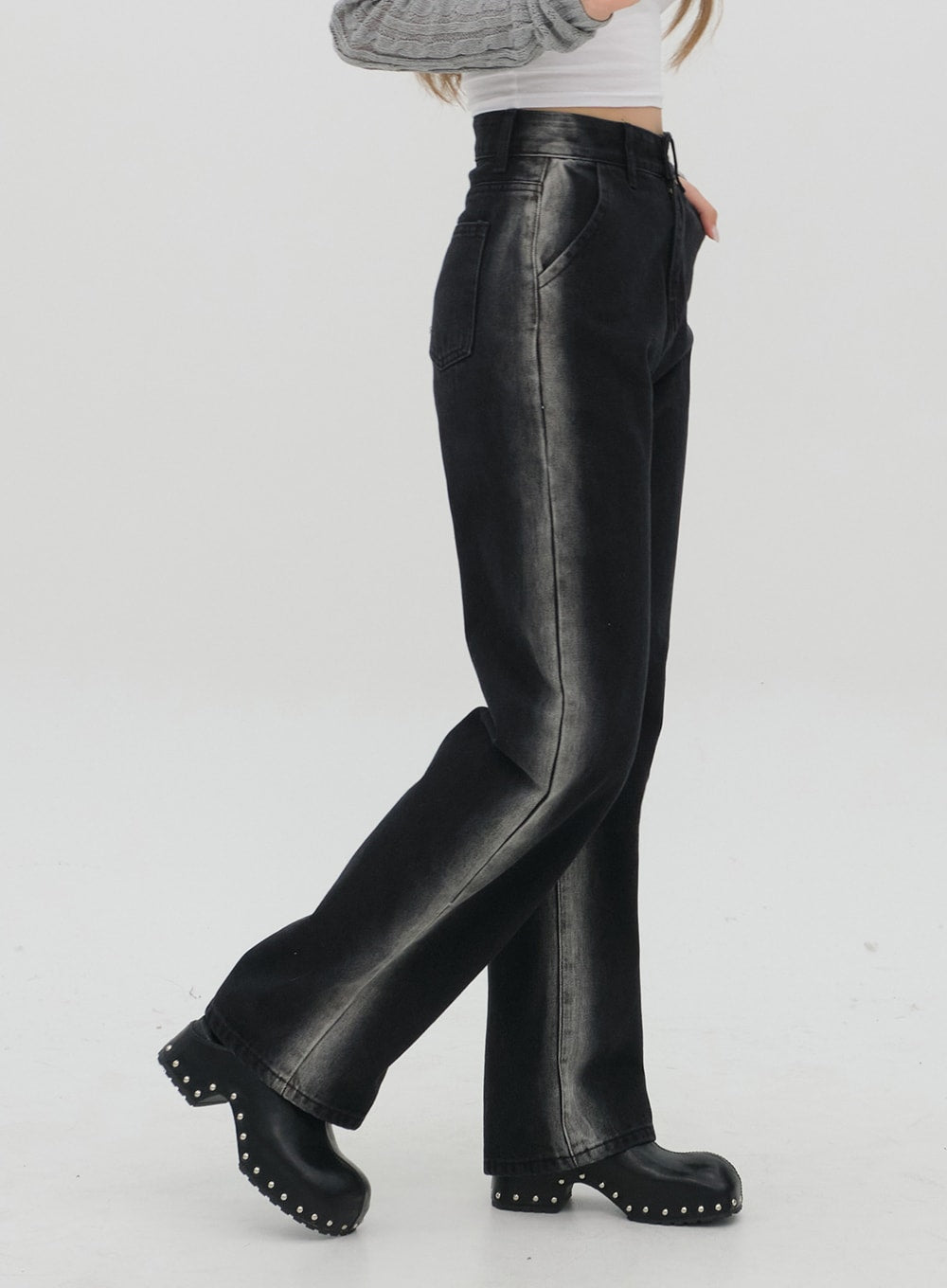 Black Jeans C1002 in washed black, side profile shot cropped at waist, contrast vertical fade stripe along outer leg clearly visible, wide straight leg, cotton denim, black studded clogs.