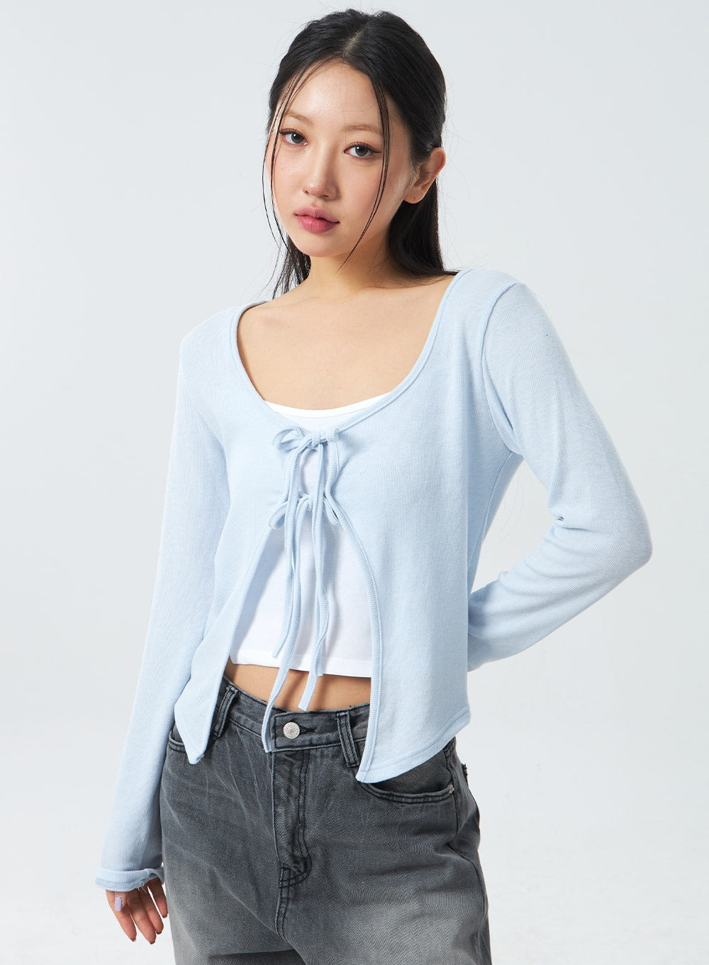 Low Rise Mid-Wash Jeans CM327 in grey, upper-body and waist close-up on model from front, low-rise waistband with button hardware visible, wide-leg cotton denim in faded grey wash.