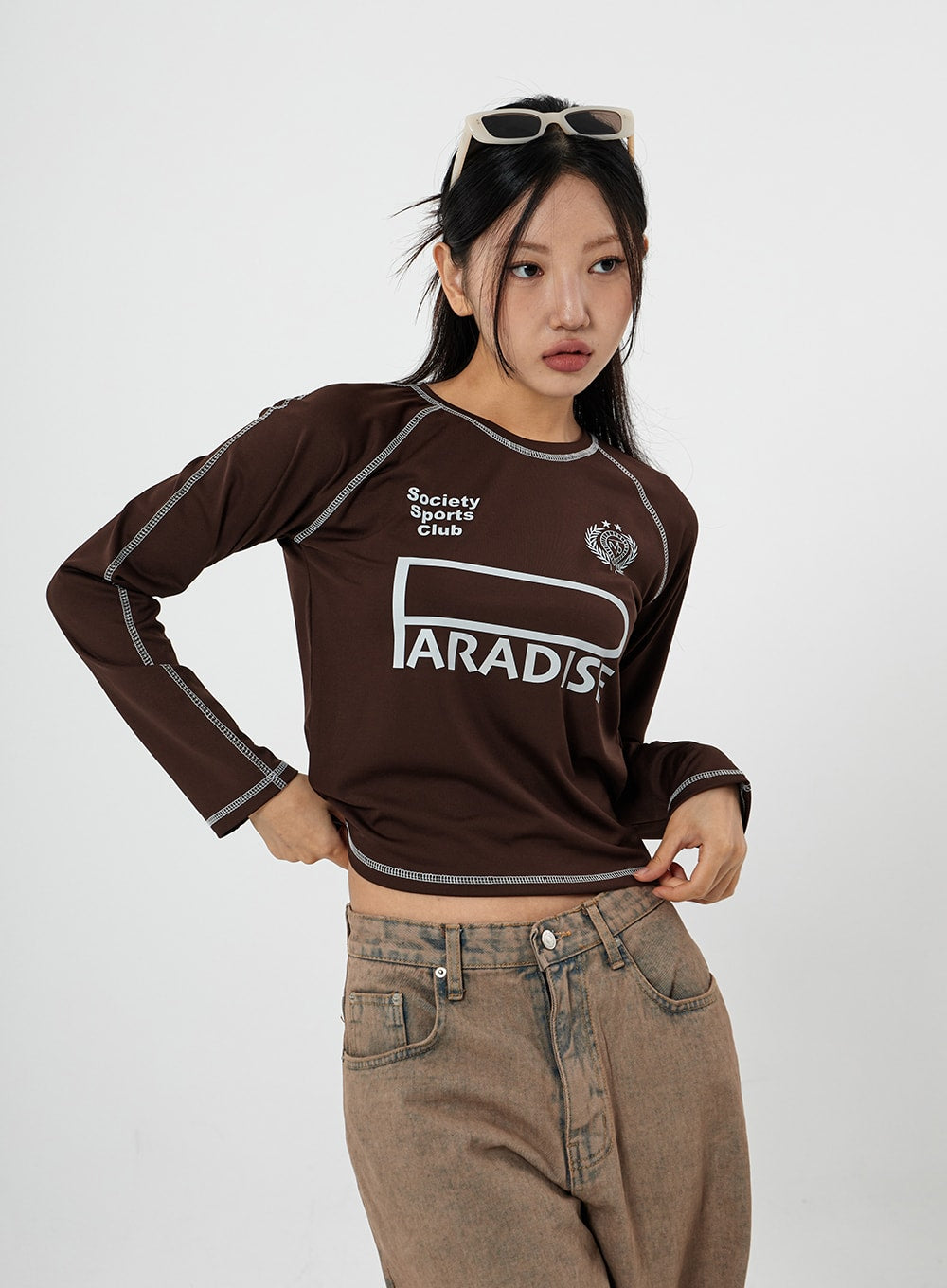Raemon Wide Jeans Unisex CS21 in brown acid-wash, upper-body and waistband close-up on model, showing mid-rise waist, front pockets, and faded brown denim texture.