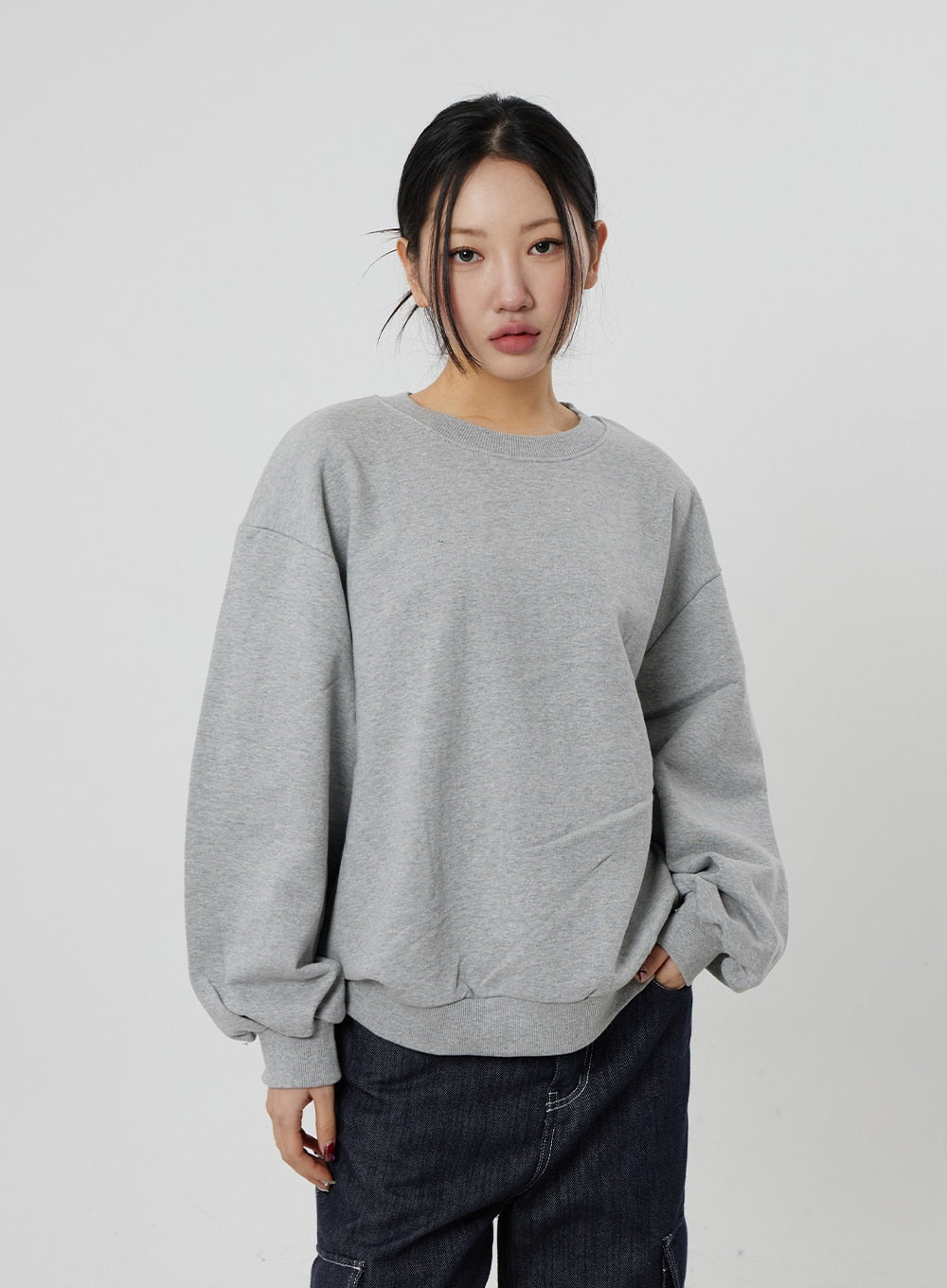 Wide Cargo Jeans CF302 in dark indigo, upper-body/waist crop on model facing front, waistband and top of wide-fit denim visible below grey sweatshirt, contrast stitch detail.