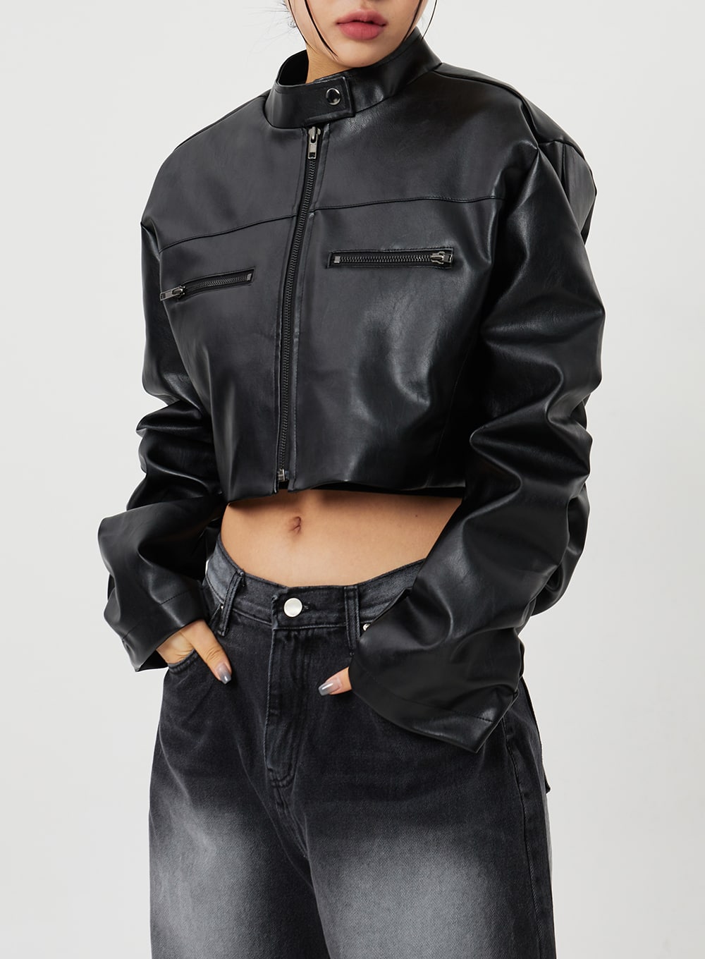 Mid-Rise Baggy Jeans CF328 in black, upper-body close-up on model, mid-rise waistband and front pocket detail visible beneath cropped faux-leather jacket, faded denim texture shown.