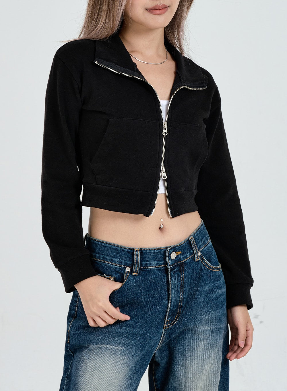 Wide Leg Faded Color Denim Pants CO11 in blue gradation, upper-body close-up on model, waistband and front pocket detail visible, faded blue cotton denim, hand in pocket, paired with black crop jacket.