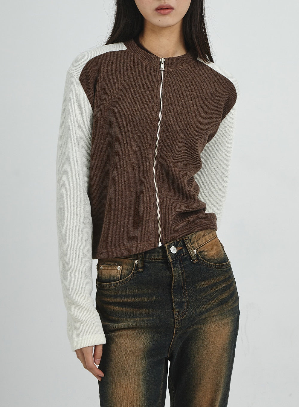 Vintage Washing Bootcut Jeans CD02 in dark washed denim, upper-half front close-up on model, warm amber wash on waistband and front pockets visible, paired with brown colorblock zip knit cardigan.
