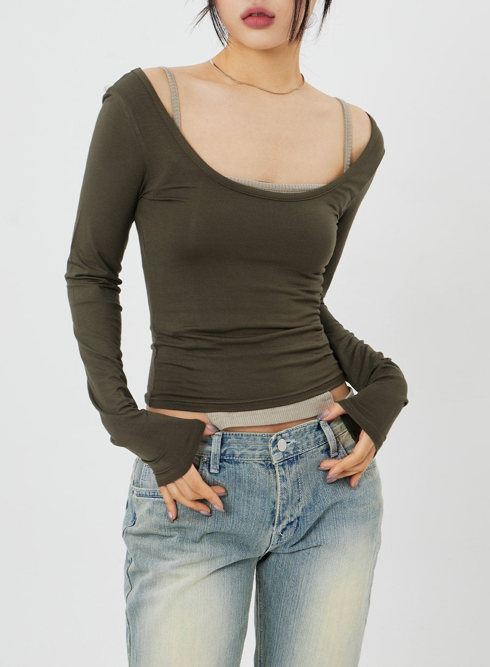 Low Rise Bootcut Jeans CF315 in light blue, upper-hip close-up on model showing low-rise waistband and front button closure, worn with olive crop top, street styling.