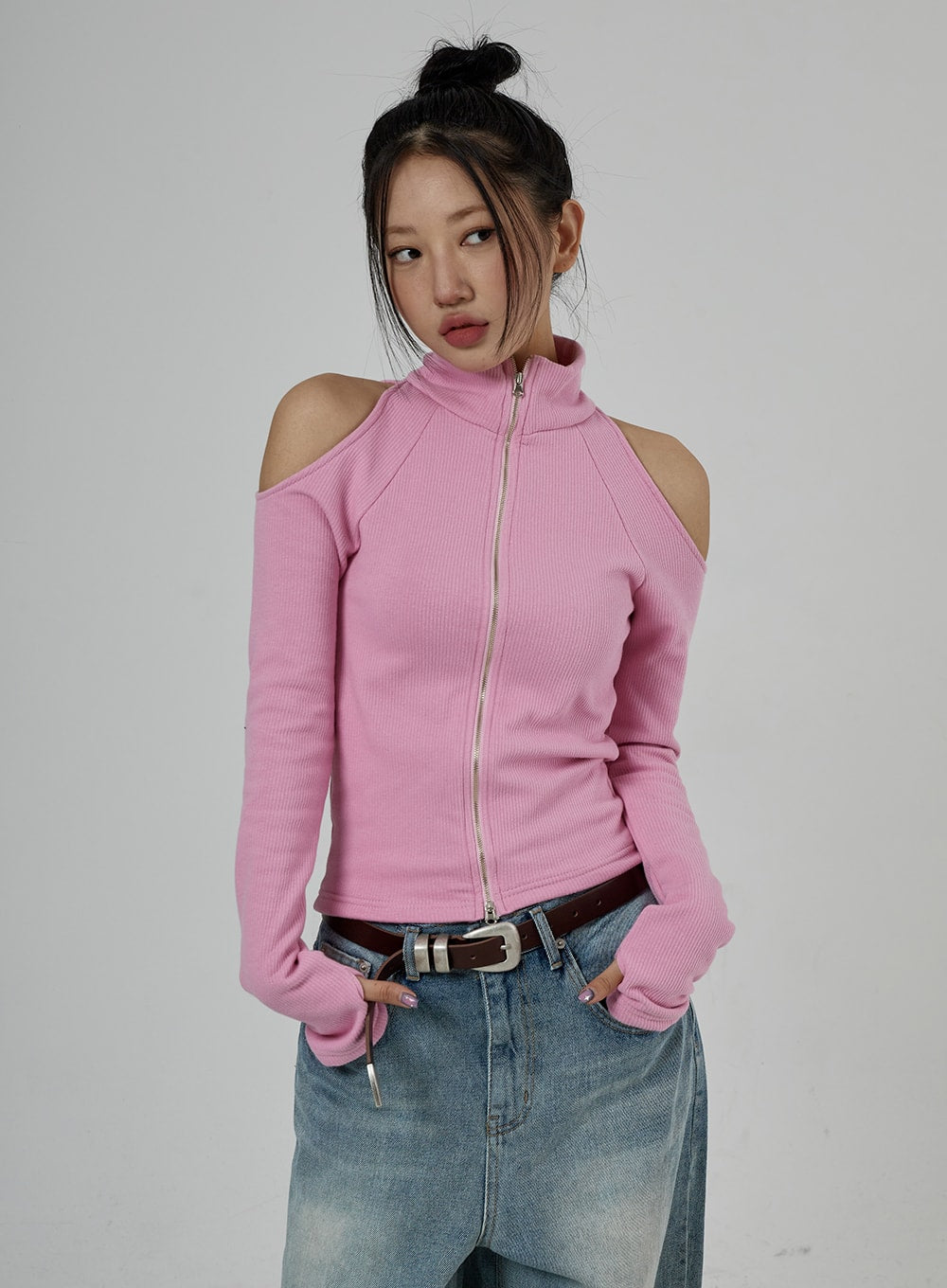 Light Wash Baggy Jeans Unisex CD26 in light blue, upper-body and waist close-up on model, washed denim waistband with belt, wide-fit top rise visible, paired with pink ribbed cold-shoulder zip top.