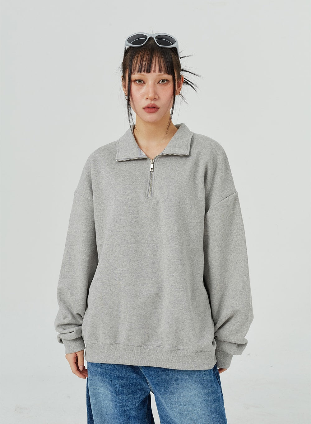 Oversized Jeans Unisex CM321 in blue, upper-body front close-up on model, wide-leg denim visible at hem, casual unisex styling with grey half-zip sweatshirt.
