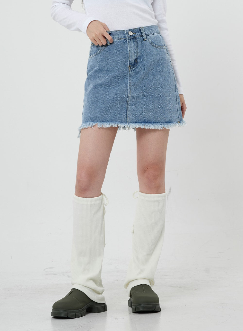 Sienna Crop Jeans Jacket CS21 in light blue, lower-body close-up on model, raw frayed hem of coordinating denim mini skirt shown, paired with white knee-high leg warmers.