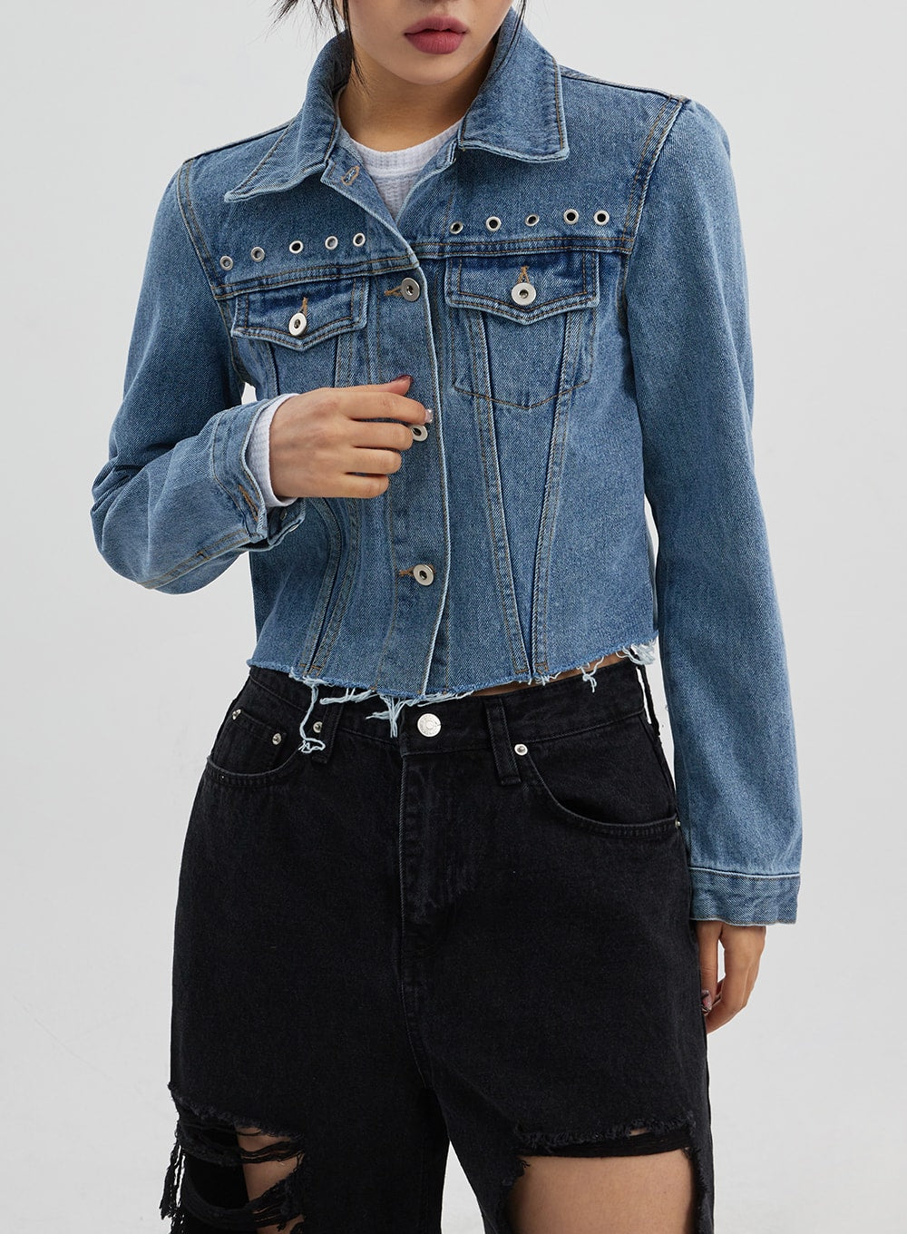 Ripped Wide Leg Jeans CJ319 in black, upper waistband close-up on model, five-pocket waistband and button fly detail, shown beneath blue denim jacket, destroyed hem visible at thigh.