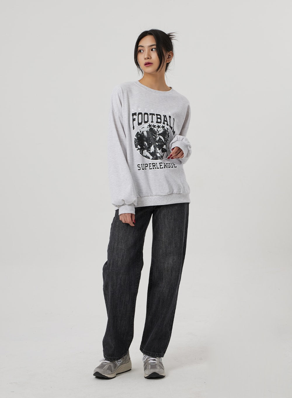Wide Straight Leg Jeans BF310 in washed black, full-length slight side view on model, high-rise wide-fit denim with relaxed straight leg, layered with grey graphic sweatshirt and sneakers.