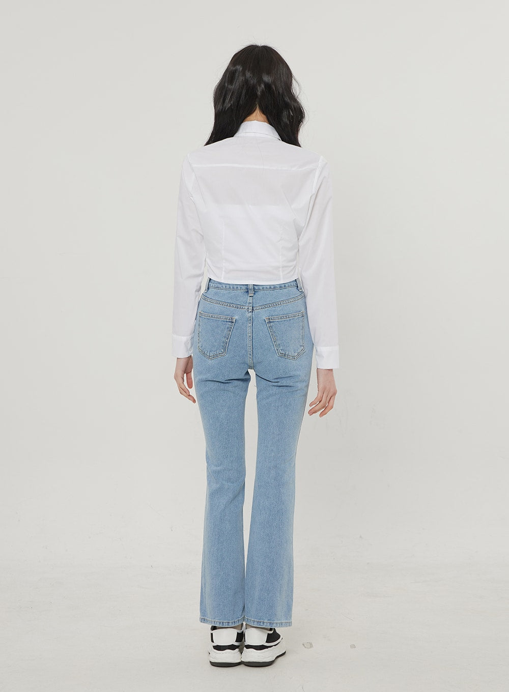 Ripped Bootcut Jeans BF306 in light blue, back full-body view on model, clean back pockets with topstitching, slim bootcut flare at hem, styled with white crop shirt.