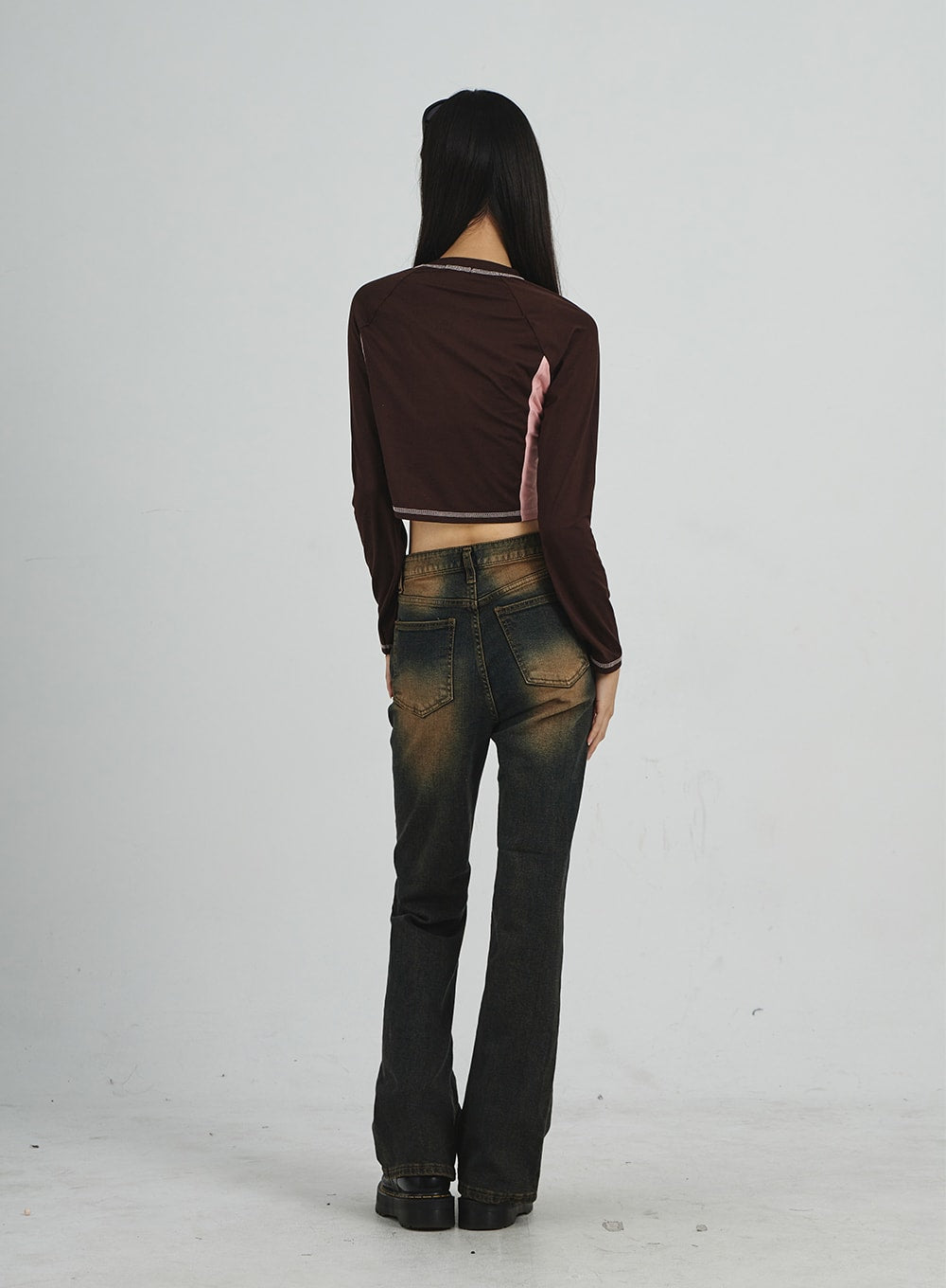 Vintage Washing Bootcut Jeans CD02 in dark washed denim, full-length back view on model, showing back pockets, amber fade across seat and legs, and bootcut hem sweep, paired with brown crop top.