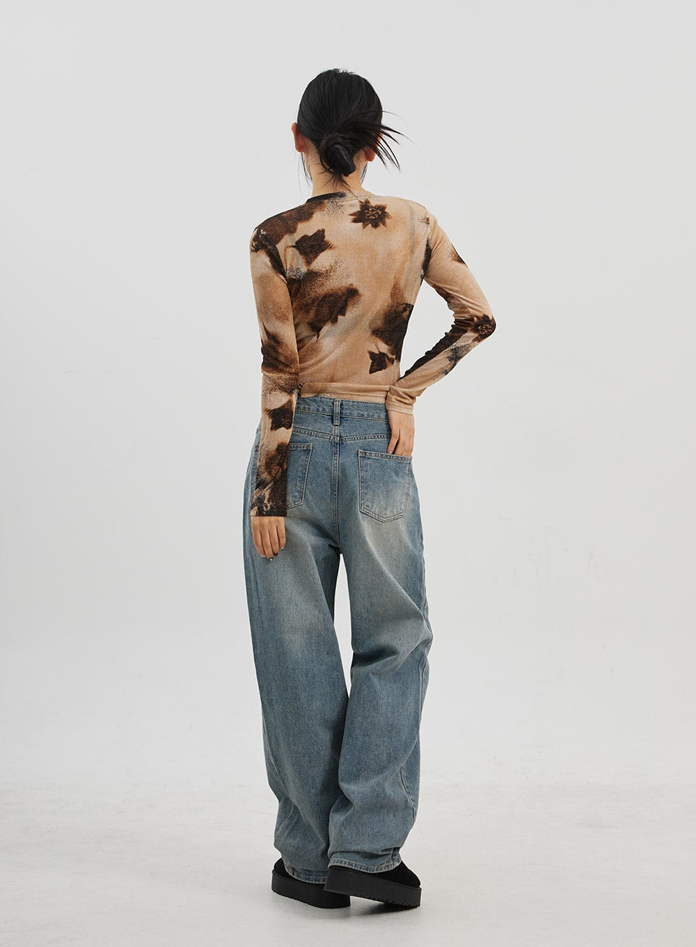 Low Rise Baggy Jeans CJ330 in Blue, full-body back shot on model, rear pockets and wide-leg faded wash denim shown, low-rise silhouette with relaxed baggy fit, platform shoes.