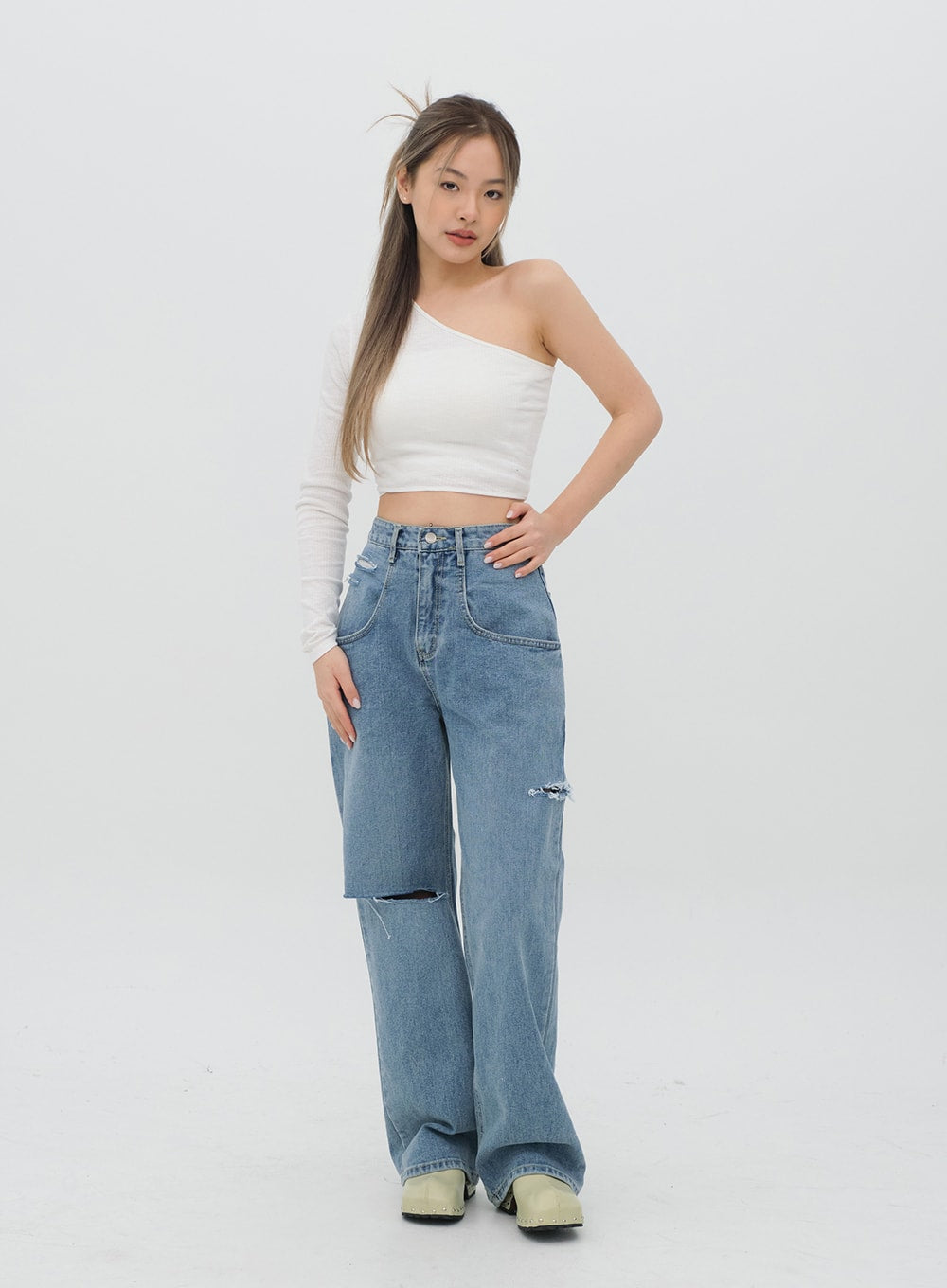 Torn Wide Leg Jeans C1002 in light blue, full-length front solo outfit shot on model, high-rise wide-leg cotton denim with knee rip, paired with white one-shoulder crop top.