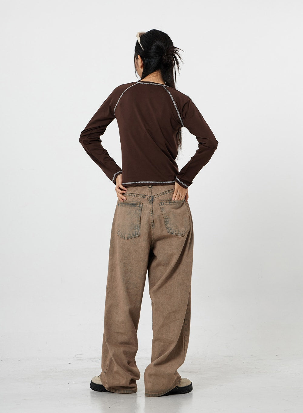 Raemon Wide Jeans Unisex CS21 in brown acid-wash, full back view on model with hands on hips, two oversized back pockets and extra-wide leg pooling at floor, tomboy silhouette.