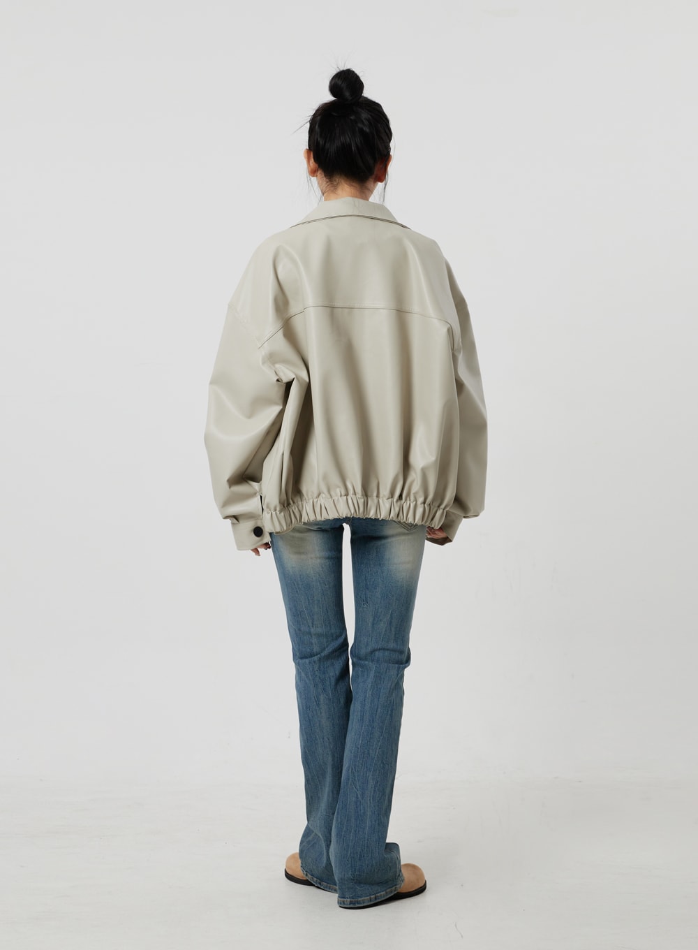 Low Rise Bootcut Jeans CF302 in blue, full-length back shot on model, bootcut flare from behind, faded blue denim with back pockets, styled with oversized beige jacket.