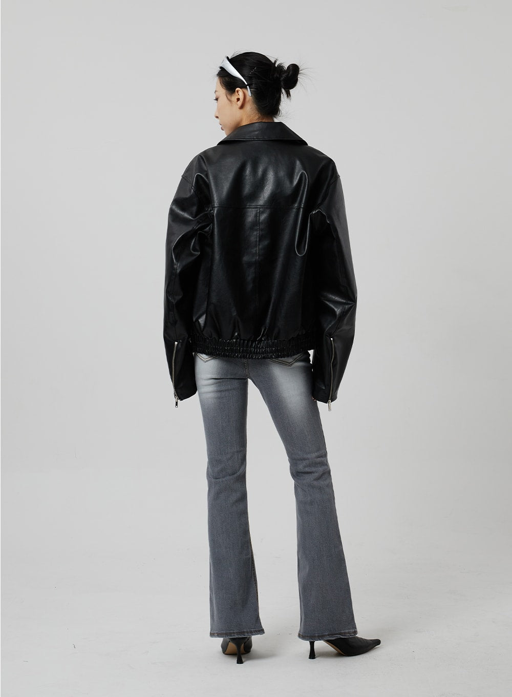 Slim Fit Bootcut Jeans CF307 in grey, full-length back view on model, bootcut flare from knee to hem clearly visible, washed grey denim, paired with black jacket and kitten heels.