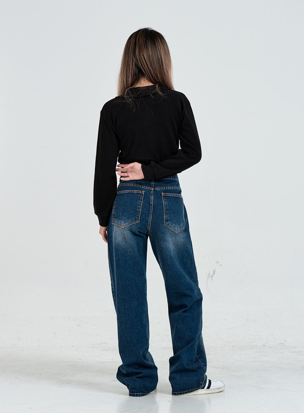 Wide Leg Faded Color Denim Pants CO11 in blue gradation, full-body back view on model, two back patch pockets, faded gradation wash on back leg, wide floor-length hem, black long-sleeve top.