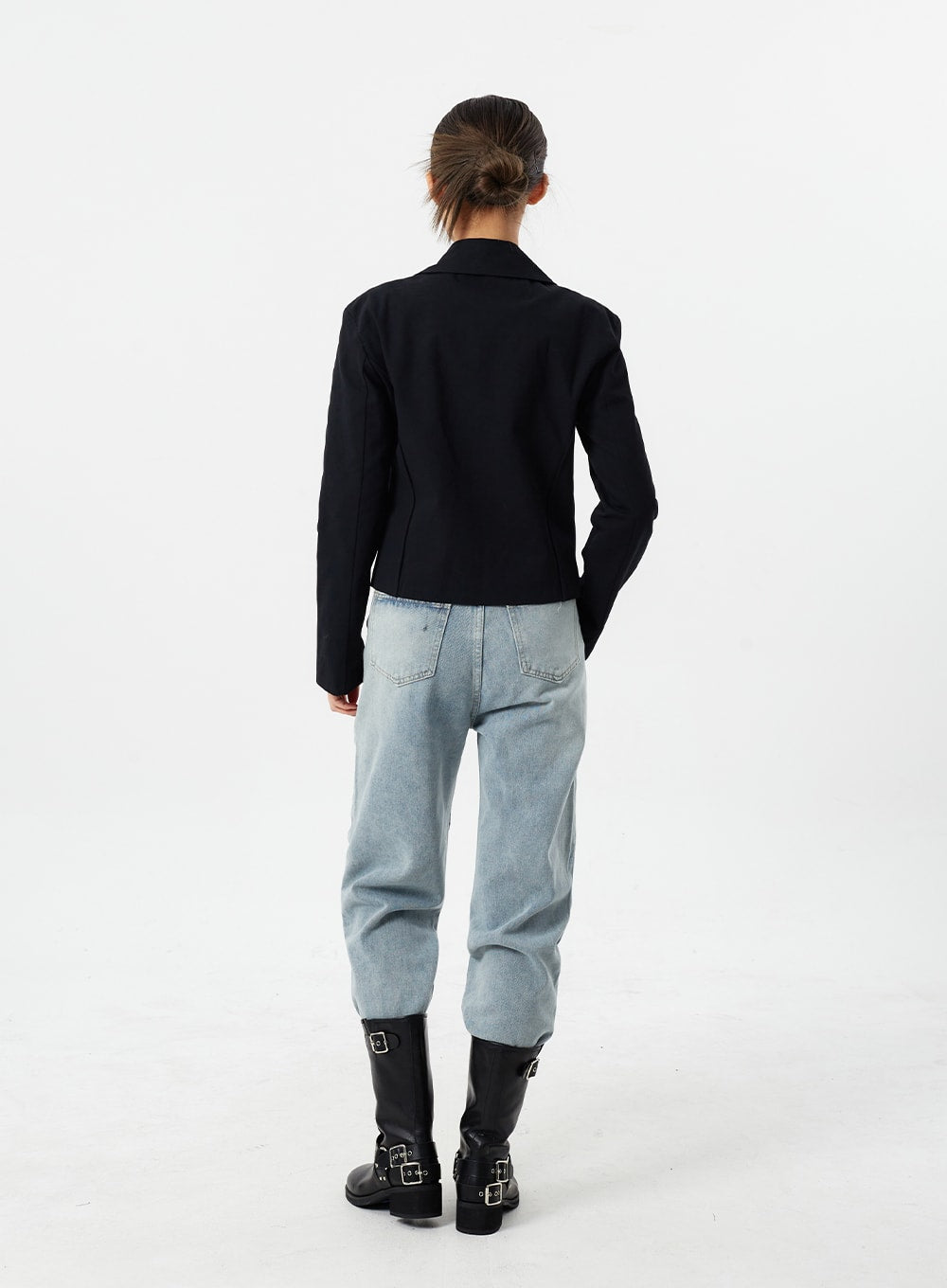 Light Wash Straight Leg Jeans CM307 in light blue, full-body back view on model, straight-fit washed cotton with clean back pockets, paired with black cropped jacket and buckle knee-high boots.