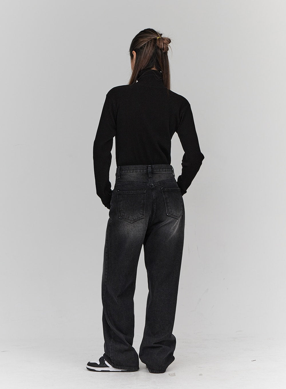 Light Washing Wide Leg Black Jeans CN23 in washed black, full-length back view on model, wide leg silhouette with dual back pockets, faded wash, paired with black ribbed turtleneck and sneakers.