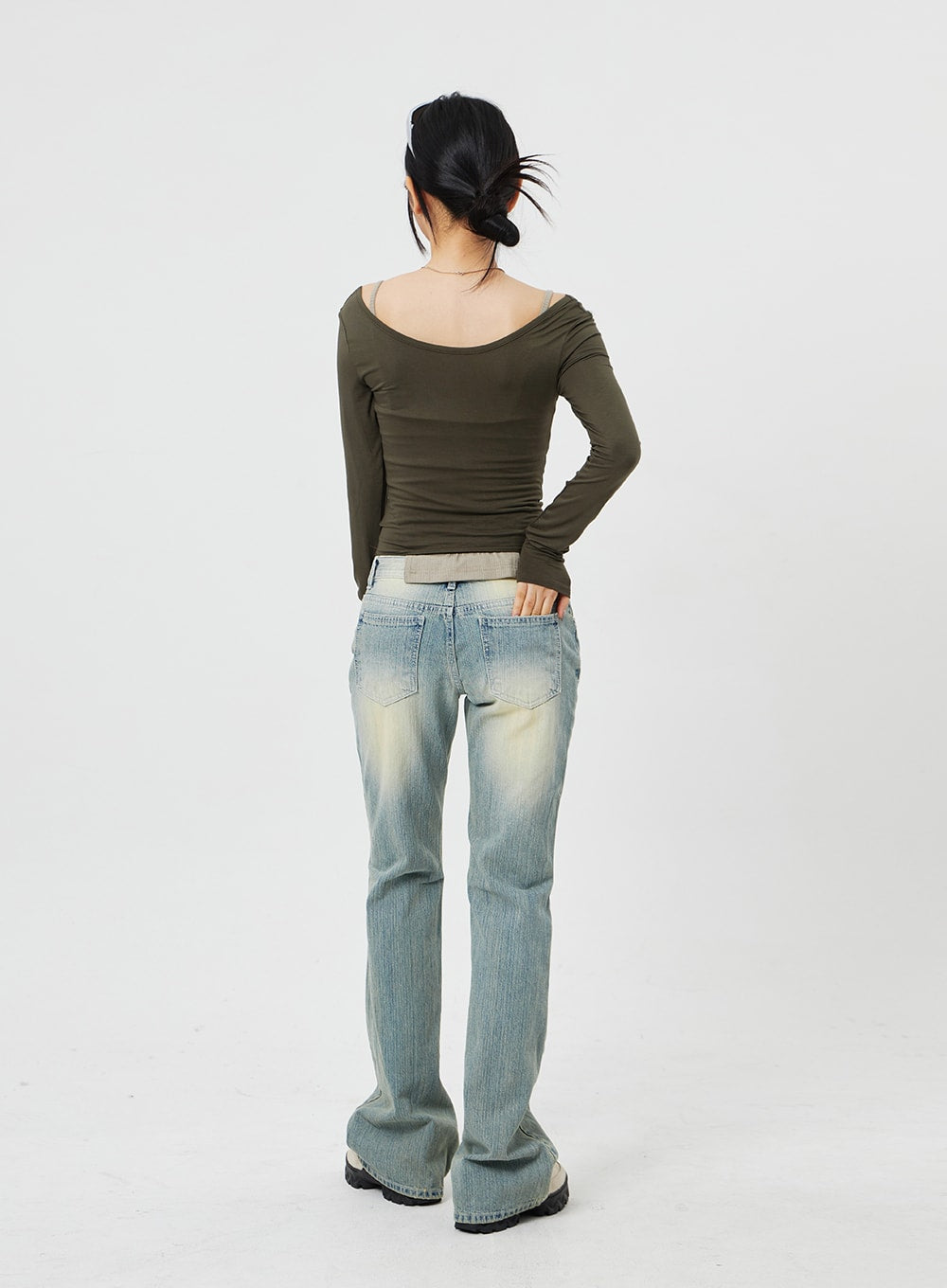 Low Rise Bootcut Jeans CF315 in light blue, back full-length shot on model, rear patch pockets and low waistband, yellow-tinted vintage fade, bootcut hem grazing the floor.