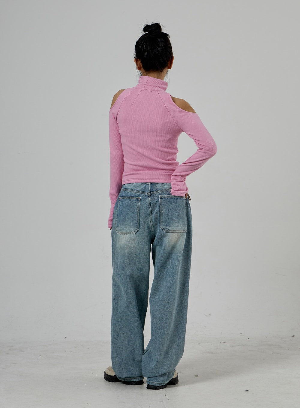 Light Wash Baggy Jeans Unisex CD26 in light blue, full-body back view on model, large patch pockets with washed fading, oversized wide-leg cotton denim, pink cold-shoulder top from behind.