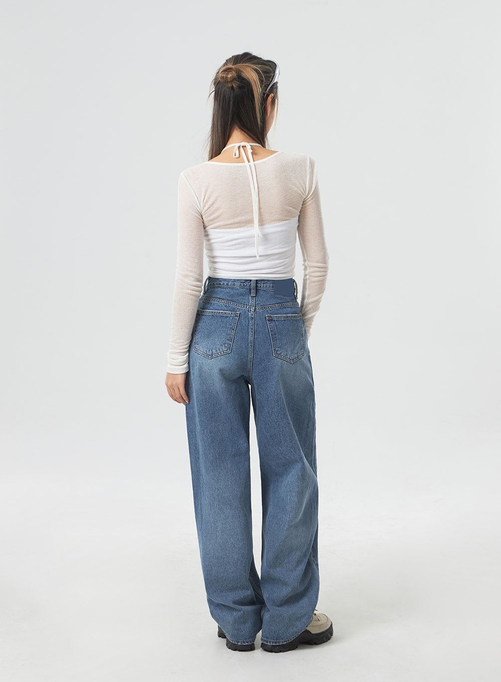 Wide Leg Mid-Wash Jeans CM331 in mid-wash blue, full-length back view on model, dual back patch pockets, wide relaxed leg with mid-wash fade, paired with white mesh long-sleeve top.