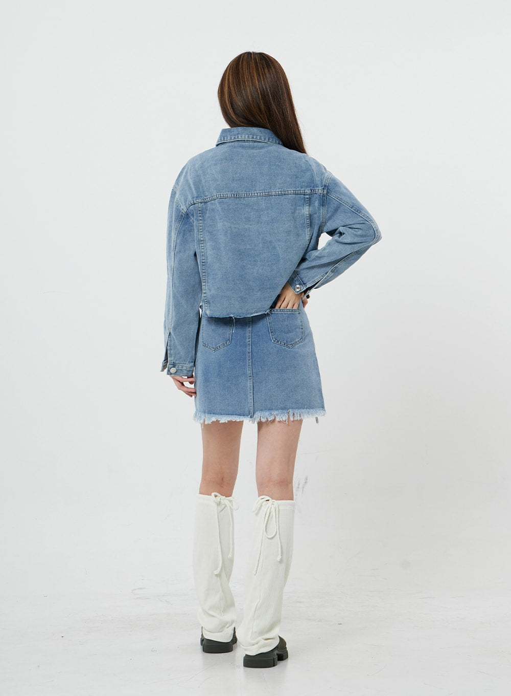 Sienna Crop Jeans Jacket CS21 in light blue, full-length back view on model, back yoke stitching and cropped hem detail shown, styled with denim mini skirt and white knee boots.